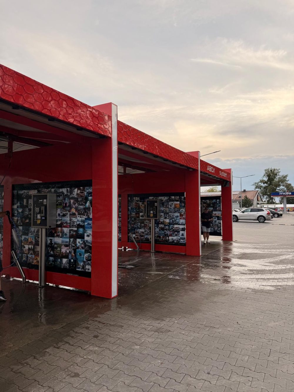 Otok reklamowy myjni samoobsługowej z oklejonymi słupami